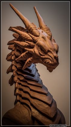 a wooden sculpture of a dragon head with long, curved horns on it's back