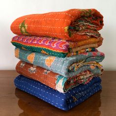 a stack of cloths sitting on top of a wooden table