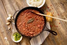 a pot filled with beans and rice on top of a wooden table