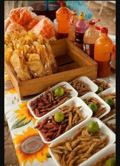 an assortment of snacks are displayed on a table with orange juices and other condiments