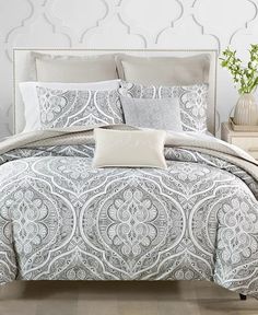 a white and grey bed with pillows on it