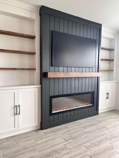 a living room with white cabinets and a flat screen tv mounted on the wall above it