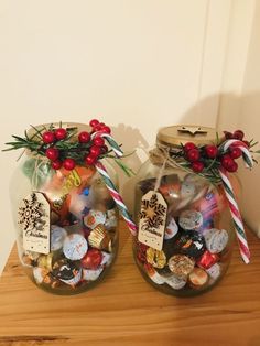 two glass jars filled with candy and candies on top of a wooden table next to each other