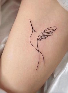 a small hummingbird tattoo on the right side of the leg, it is black and white