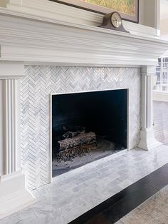 a white fireplace with a clock on the mantle