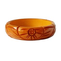 "Item: This is a lovely bakelite bangle bracelet carved with flowers and leaves on either side. It was made in the late 1930s and has a very deep yellow / orange color. It's in excellent condition, has been tested and guaranteed vintage bakelite. Be sure to check our other listings for lots more bakelite jewelry! Measurements: 3/4\" wide - 2 1/2\" inner diameter, 3\" outer diameter, 7 3/4\" inner circumference. Condition: 9.5 - Excellent Shipping: U.S shipping is $5.00 for USPS First Class Mail Vintage Bakelite Bracelet, Vintage Bakelite Bangle Jewelry, Vintage Bakelite Bangle, Retro Bakelite Jewelry As Gift, Retro Bakelite Jewelry, Retro Round Bakelite Jewelry, Vintage Carved Orange Jewelry, Orange Carved Vintage Jewelry, Vintage Orange Carved Jewelry