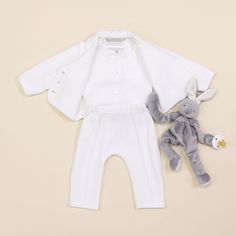 Handmade in the USA A special newborn suit for your newest addition. The all white Elijah baby suit was designed to mix the softest, quality materials with elegant style. No detail is missed on this darling 3-piece coming home outfit. The jacket and pants are made with a soft white quilted cotton to keep him cozy. The fitted style pant features pleated front creases, a grosgrain ribbon and shell buttons at waist, and a stylish back pocket. The adorable jacket features a fold over collar, cute fr Classic Long Sleeve Sets For Baptism, Cream Long Sleeve Baptism Set, White Sets For Baptism In Spring, Classic White Sets For Baptism, Classic White Set For Baptism, Baby Boy Formal Wear, Boys Formal Wear, Baby Photoshoot Boy