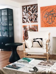 a living room filled with furniture and pictures on the wall