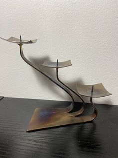 a metal sculpture sitting on top of a wooden table