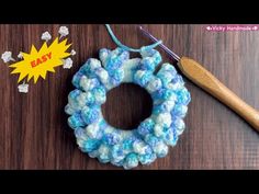 a crocheted wreath with a wooden knitting needle next to it