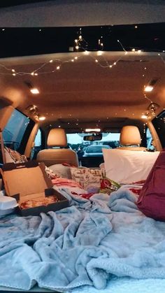 the back of a car filled with boxes and other items on top of a blanket