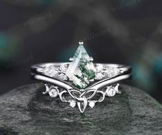 a white gold ring with an emerald stone and diamond accents