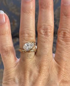 a woman's hand with an engagement ring on it and a diamond in the middle