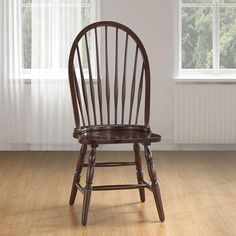 a wooden chair sitting in front of a window on top of a hard wood floor