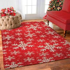 a red area rug with snowflakes on it in front of a christmas tree