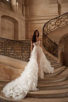 a woman in a wedding dress standing on some stairs