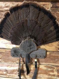 a wooden wall mounted with a large feather fan