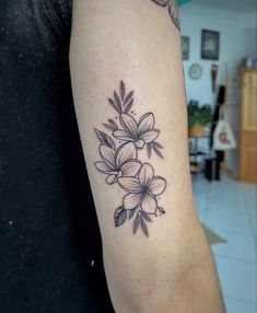 a black and white flower tattoo on the arm