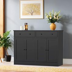 a black cabinet with two vases on top of it next to a yellow rug