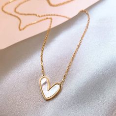 With a simple, yet bold feel this necklace brings, it is the perfect compliment to any outfit! Necklace Details: * 3/4" Gold / Mother of Pearl Heart Pendant * 18K gold / Stainless Steel Necklace Sizing: * 15" with 2" Extender (View Chart if Needed) Every piece of jewelry you order is delivered in an elegant organza bag. For that extra special touch, consider our upgraded Gift Package Option during checkout making your gift-giving experience truly memorable. Heart Necklace Aesthetic, Pearl Heart Necklace, Feminine Necklace, Mother Of Pearl Pendant, Necklace For Mom, Fancy Jewellery Designs, Jewelry Set Design, 18k Gold Necklace, Pearl Heart