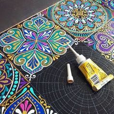 the paint is being used to create an intricately designed table top with colorful designs