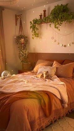 a bed with an orange comforter, pillows and blankets on it in a bedroom