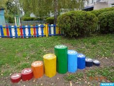 colorfully painted concrete blocks sitting in front of a blue and yellow fence with numbers on them