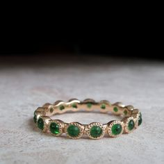 a gold ring with green stones on it