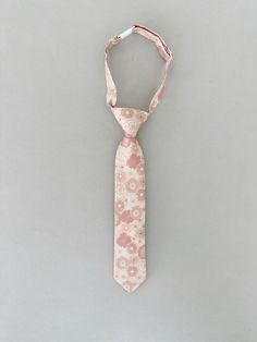 Let your little one look classy and dapper for any special occasion with our Mason Tie! It's great for kids and provides a comfortable fit - plus, this retro floral pattern in pink pairs perfectly with any of our other floral ties. Spruce up their look today! Named after Mason who we count on for good vibes and funny jokes to brighten our day at work. 5-8: 14 Inches 2-4: 10.5 Inches Adjustable Pink Tie, Adjustable Pink Ties For Summer, Classic Pink Tie For Spring, Classic Pink Ties For Spring, Pink Floral Print Tie For Summer, Pink Floral Print Ties For Summer, Pink Floral Print Ties For Spring, Pink Floral Print Summer Ties, Floral Ties