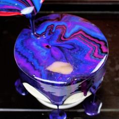 a purple and blue liquid pouring into a bowl