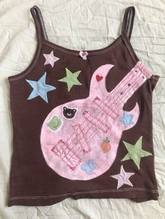 a child's tank top with an image of a pink guitar and stars on it