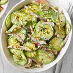 a white bowl filled with cucumbers and onions