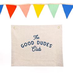 the good dude's club banner hanging on a string with colorful flags in the background