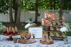 a table topped with pastries and desserts on top of a blue and white table cloth