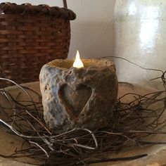 a stone candle holder sitting on top of a table next to a wicker basket