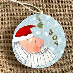 a ceramic ornament with an image of a santa clause on it's face