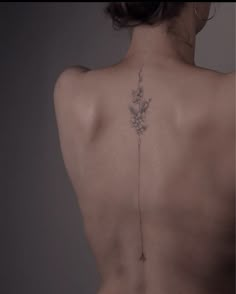 the back of a woman's body with flowers on her left shoulder and lower back