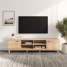 a living room with a large flat screen tv on top of a wooden entertainment center