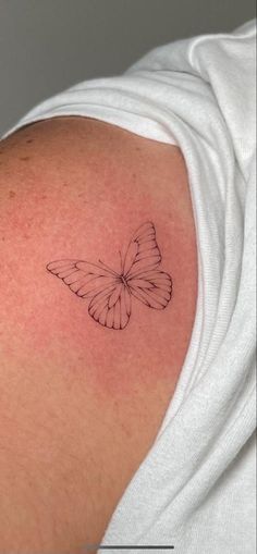 a small butterfly tattoo on the shoulder