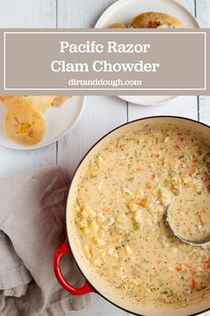 a red pot filled with clam chowder next to two plates