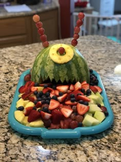 a watermelon shaped like a monster with fruit in it's mouth on top of a blue tray