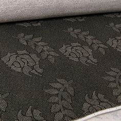 an upholstered couch with black and white floral design on it's back