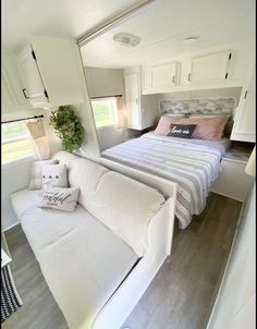 a bed sitting in the middle of a bedroom next to a couch with pillows on it