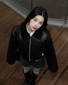 a woman in black jacket standing on wooden floor