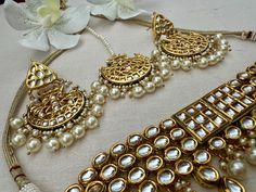 Southasian Indian Bollywood pakistani wedding gold jadau pearls Kundan meenakari bridal choker necklace chandbali earrings Mangtika jewelry Jewellery set gifts for her Statement bridal necklace set  choker necklace -  5.25" width at the center, adjustable length slider bead closure earrings - 2.75" x 1.5" push back closure Slight variations are characteristics of handmade products and not flaws. Digital colors can slightly vary from real ones. Traditional Gold Kundan Chandbalis, Gold Kundan Necklace With Stone Work For Eid, Festive Chandbali Bridal Sets For Eid, Gold Kundan Necklace Bollywood Style For Eid, Chandbali Bridal Necklace For Eid Wedding, Kundan Bridal Sets For Wedding And Eid, Gold Bridal Earrings With Stone Work For Ceremonial, Gold Round Tikka For Wedding, Gold Wedding Tikka