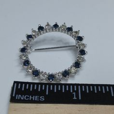 *Description: This is a beautiful Panetta dainty circular brooch with clear and dark blue rhinestones on a rhodium plated setting. The brooch is stamped PANETTA on the back on a raised cartouche. This would be a great addition to your vintage jewelry collection or make a great vintage gift! *Approximate Measurements: Length & Width - 1 3/16 Inches, Weight - .2 Ounce *Condition: Great vintage condition. Will see signs of wear under magnification. See photos for details. *Hallmark: Panetta *It Blue Round Brooch For Formal Occasions, Formal Blue Round Brooches, Formal Blue Round Brooch, White Gold Round Brooches For Anniversary, White Gold Round Brooch For Anniversary, Anniversary Rhinestone Round Brooches, Anniversary Round Brooches With Rhinestones, Anniversary Brooches With Rhinestones, Anniversary Round Rhinestones Brooches