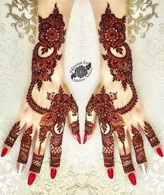 two hands with henna designs on them and red nail polishes in the middle