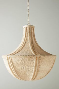 a light fixture hanging from a ceiling with chains attached to the lightshade,