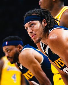 three basketball players with headbands on standing in front of the camera and looking off to the side