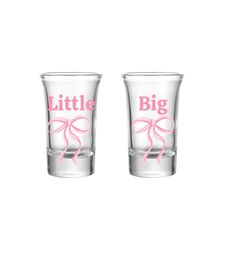 two shot glasses with pink bows and the words little, big on each one side